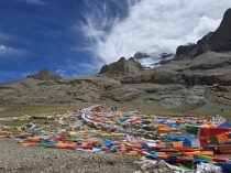 Il volto sacro del monte Kailash attraverso un velo di bandiere di preghiera (copyright: Reteluna.it)